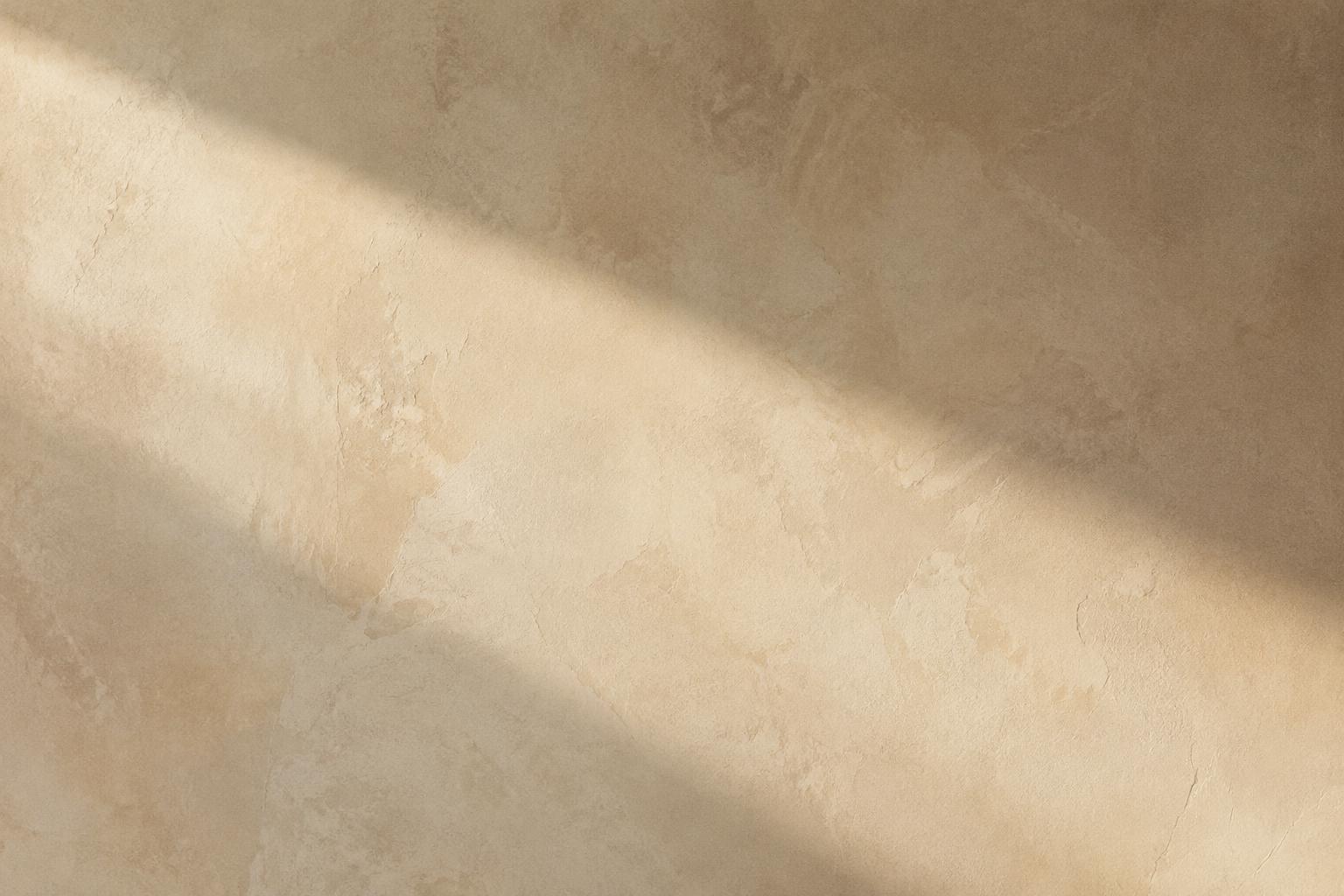 Warm limewash plaster crossed by a band of afternoon light